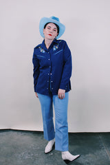 Women's vintage western style 1970's California Ranchwear label long sleeve navy blue blouse with pointy collar and pearly blue popper buttons. Has floral embroidery on shoulders.
