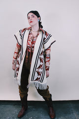 Women's vintage western style 1970's knee length cream colored blanket vest. Sleeveless with tassel closure and fringe trim. Bird and leaf print.
