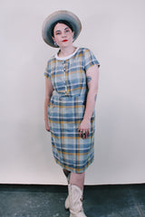 Women's vintage western style 1960's short sleeve midi length plaid print shift dress with white scalloped trim. Grey, teal, and mustard yellow colors.
