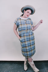 Women's vintage western style 1960's short sleeve midi length plaid print shift dress with white scalloped trim. Grey, teal, and mustard yellow colors.