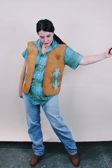 Women's or men's western style vintage 1970's sleeveless brown tan colored suede vest with all over teal colored hand painting.