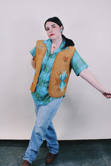 Women's or men's western style vintage 1970's sleeveless brown tan colored suede vest with all over teal colored hand painting.