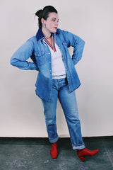 Women's or men's vintage 1980's Wrangler, Preshrunk, X-Long Tails, Made in USA label long sleeve medium wash denim Wrangler western style button up shirt with pearl popper buttons.