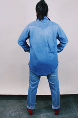 Women's or men's vintage 1980's Wrangler, Preshrunk, X-Long Tails, Made in USA label long sleeve medium wash denim Wrangler western style button up shirt with pearl popper buttons.