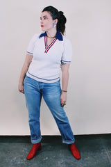 Women's or men's vintage 1970's short sleeve white top with navy collar, two button half closure in a nubby textured stretchy polyester material.