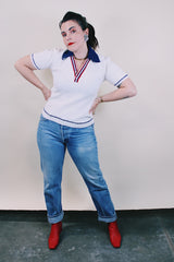 Women's or men's vintage 1970's short sleeve white top with navy collar, two button half closure in a nubby textured stretchy polyester material.