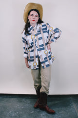 Women's or men's western style vintage 1970's Spire California label long sleeve white polyester button up collared shirt with an all over brown, yellow, and grey belt print.