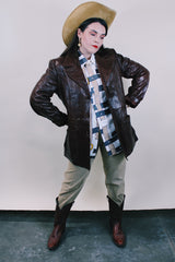 Men's or Women's western style vintage 1980's Fantastic International, Fashions From The World label long sleeve chocolate brown leather button up jacket with pointy double lapel and pockets.