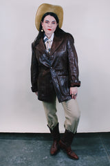 Men's or Women's western style vintage 1980's Fantastic International, Fashions From The World label long sleeve chocolate brown leather button up jacket with pointy double lapel and pockets.