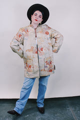 Women's vintage 1960's long sleeve and long length gold colored silk robe kimono with all over multicolored embroidered floral design. Pockets, mandarin collar and fabric covered buttons