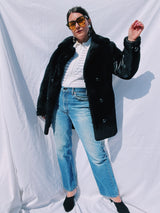 black faux fur coat with collar and buttons up the front and leather panels under the arms and on the side