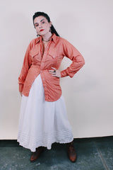 Men's or women's vintage western style 1970's Ely Plains Rider, Ely C. Walker USA label long sleeve shirt with pearl snapper buttons, chest pockets, dagger collar in orange with rose print.