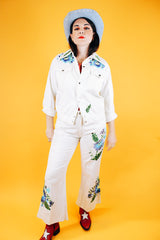 white jacket and pant set with floral embroidery throughout vintage women's 1970's