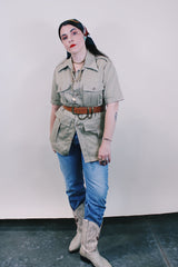 Women's or men's vintage safari style 1970's Montgomery Ward label short sleeve button up tan colored shirt in cotton with four pockets, dagger collar, side slits, and wood buttons.