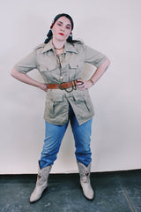 Women's or men's vintage safari style 1970's Montgomery Ward label short sleeve button up tan colored shirt in cotton with four pockets, dagger collar, side slits, and wood buttons.