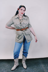 Women's or men's vintage safari style 1970's Montgomery Ward label short sleeve button up tan colored shirt in cotton with four pockets, dagger collar, side slits, and wood buttons.