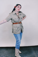 Women's or men's vintage safari style 1970's Montgomery Ward label short sleeve button up tan colored shirt in cotton with four pockets, dagger collar, side slits, and wood buttons.