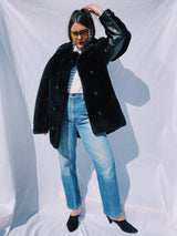 black faux fur coat with collar and buttons up the front and leather panels under the arms and on the side