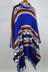 Women's or men's vintage 1970's blue acrylic material poncho with fringe trim and half zipper closure at neck. White. black, brown, and red striped print.