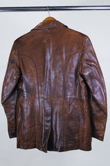 Men's or Women's western style vintage 1980's Fantastic International, Fashions From The World label long sleeve chocolate brown leather button up jacket with pointy double lapel and pockets.