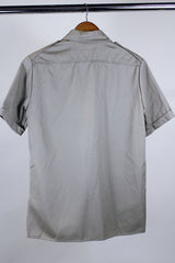 Women's or men's vintage safari style 1970's Montgomery Ward label short sleeve button up tan colored shirt in cotton with four pockets, dagger collar, side slits, and wood buttons.