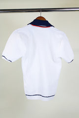 Women's or men's vintage 1970's short sleeve white top with navy collar, two button half closure in a nubby textured stretchy polyester material.