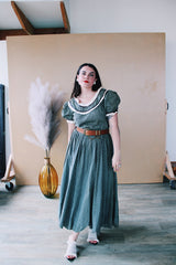 Women's vintage 1940's short sleeve maxi length cotton material prairie style dress with white and black ribbon trim around neckline and cuffs. Scalloped hem.