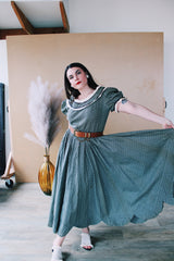 Women's vintage 1940's short sleeve maxi length cotton material prairie style dress with white and black ribbon trim around neckline and cuffs. Scalloped hem.