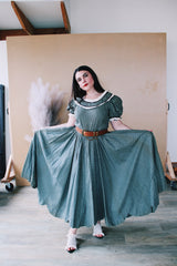 Women's vintage 1940's short sleeve maxi length cotton material prairie style dress with white and black ribbon trim around neckline and cuffs. Scalloped hem.