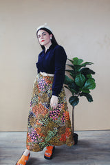 Women's vintage 1960's Lounging Apparel Evelyn Pearson label long sleeve maxi length twofer house dress with a black velvet top part and multicolored floral print skirt.