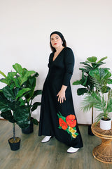 Women's vintage 1970's long sleeve maxi length black polyester material dress with big red and green flower graphic on the side