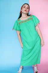 Women's vintage 1970's short sleeve cotton material green short sleeve ankle length dress with orange embroidery and a square neckline and puff sleeves.