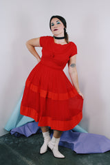 Women's vintage 1960's short sleeve capped sleeve knee length midi dress in vibrant red with a scoop neckline and flower on chest.