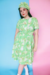 Women's vintage 1960's Martha Manning Original label short sleeve midi length green floral print dress with matching belt and pleated skirt bottom.