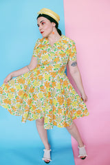 Women's vintage 1960's short sleeve polyester material mini length dress with all over green, orange, and yellow floral print.