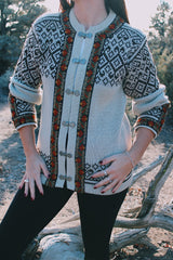long sleeve wool Norwegian sweater with silver metal closures for buttons cream with brown, green, and orange print
