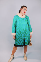 green statin long sleeve knee length jacket with floral pattern and cream faux fur trim around cuffs and neck vintage 1960's