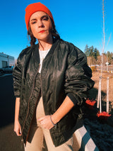 black satin long sleeve bomber jacket with orange interior that is reversible