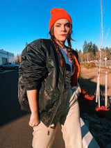 black satin long sleeve bomber jacket with orange interior that is reversible