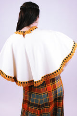 women's 1950's cream wool poncho with orange yarn fringe hem and neck