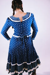 women's vintage 1970's prairie dress in navy blue with ditsy floral print cream crochet trim throughout tie waist and two tiered skirt