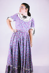 purple floral 1950's prairie dress with large full skirt and black ribbon bows