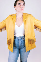 tan women's vintage 1970's genuine leather jacket with fringe, pockets, and double lapel