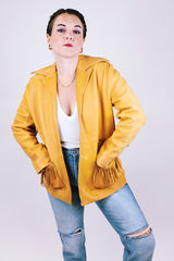 tan women's vintage 1970's genuine leather jacket with fringe, pockets, and double lapel