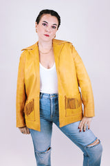 tan women's vintage 1970's genuine leather jacket with fringe, pockets, and double lapel