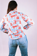 long sleeve 1970's women's vintage button up blouse with collar in a red and blue western print with cowboy hats and boots