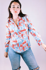 long sleeve 1970's women's vintage button up blouse with collar in a red and blue western print with cowboy hats and boots