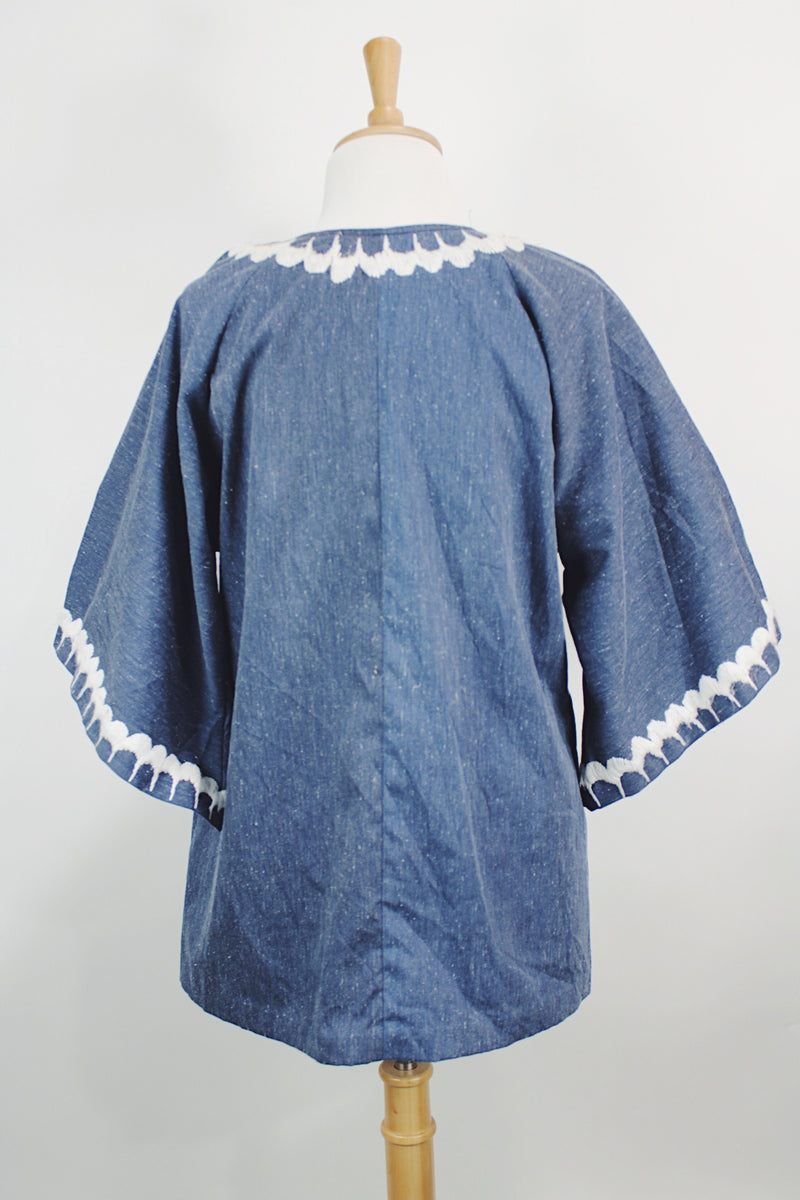 Women's vintage 1970's blue chambray tunic blouse with flared sleeves and a V shaped neckline. Has a white embroidered bird on the front.