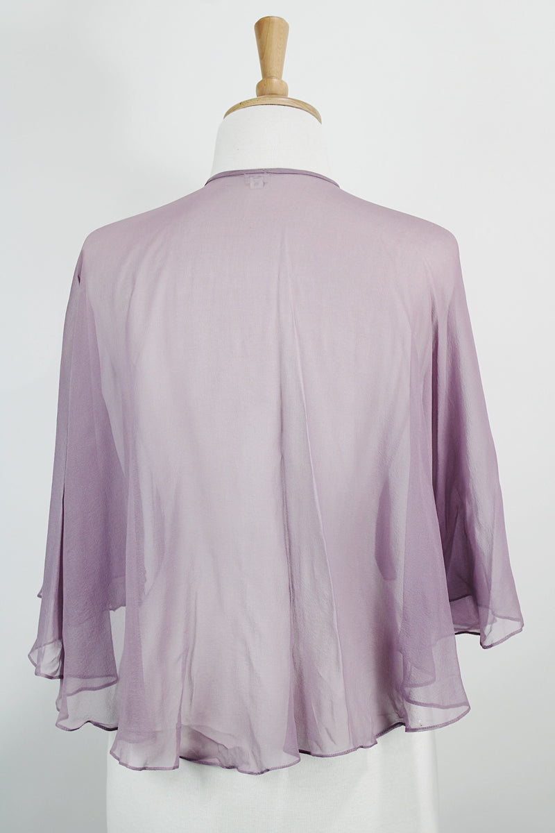 Women's vintage 1980's sheer silk material cape blouse in a light purple color. Has one hook and eye closure at neck with attached bow. 