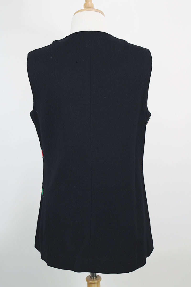 Women's vintage 1970's Palena Knitwear, Made in Hong Kong label sleeveless black wool vest with brass buckles closures up the front and floral trim details.